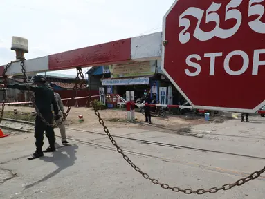 Petugas kepolisian setempat berjaga di jalan yang diblokir dekat bandara Internasional Phnom Penh di Phnom Penh, Kamis (15/4/2021). Pemimpin Kamboja memutuskan untuk lockdown atau karantina Phnom Penh selama dua minggu mulai Kamis (15/4) menyusul kenaikan tajam kasus COVID-19. (AP Photo/Heng Sinith)