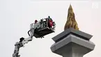 Pengunjung menaiki Bronto Skylift yang disediakan petugas pemadam kebakaran di Monas, Jakarta, Minggu (23/11). Bronto Skylift merupakan fasilitas yang disediakan Pemprov DKI Jakarta untuk melihat Monas dari dekat. (Liputan6.com/JohanTallo)