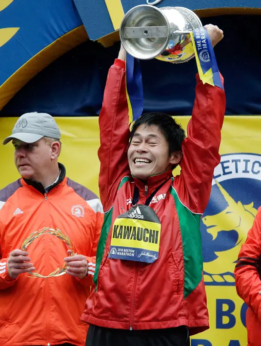 Pelari Jepang, Yuki Kawauchi mengangkat trofi seusai memenangkan Boston Marathon ke-122 di Boston, Senin (16/4). Yuki Kawauchi menjadi pelari Jepang pertama yang berhasil menjadi juara Maraton Boston sejak 1987. (AP/Elise Amendola)