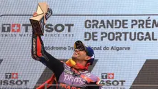 Pembalap Prima Pramac Ducati Racing, Jorge Martin mengangkat trofi saat merayakan kemenangannya di atas podium setelah memenangi balapan MotoGP Portugal di Sirkuit Internasional Algarve, Portimao, 24 Maret 2024. (PATRICIA DE MELO MOREIRA/AFP)