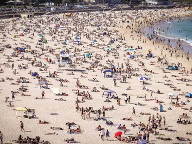 Orang-orang mengunjungi pantai Bondi di Sydney, Australia pada 5 Oktober 2020. Pengunjung ramai berjemur dan bermain di pantai dan berenang di laut saat pandemi Covid-19 masih berlangsung.  (Photo by DAVID GRAY / AFP)