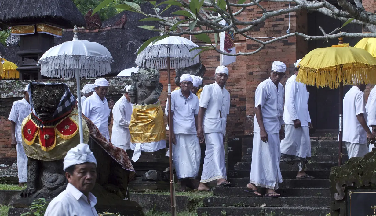 Warga Bali beraktivitas di dekat lokasi yang akan dikembangkan menjadi resor bintang 6 yang dikelola oleh Trump Organization di Beraban, Bali, Rabu (12 /4). Trump berjanji dalam pembangunannya tersebut tidak akan mengubah sisi kebudayaan Bali.(AP Photo)