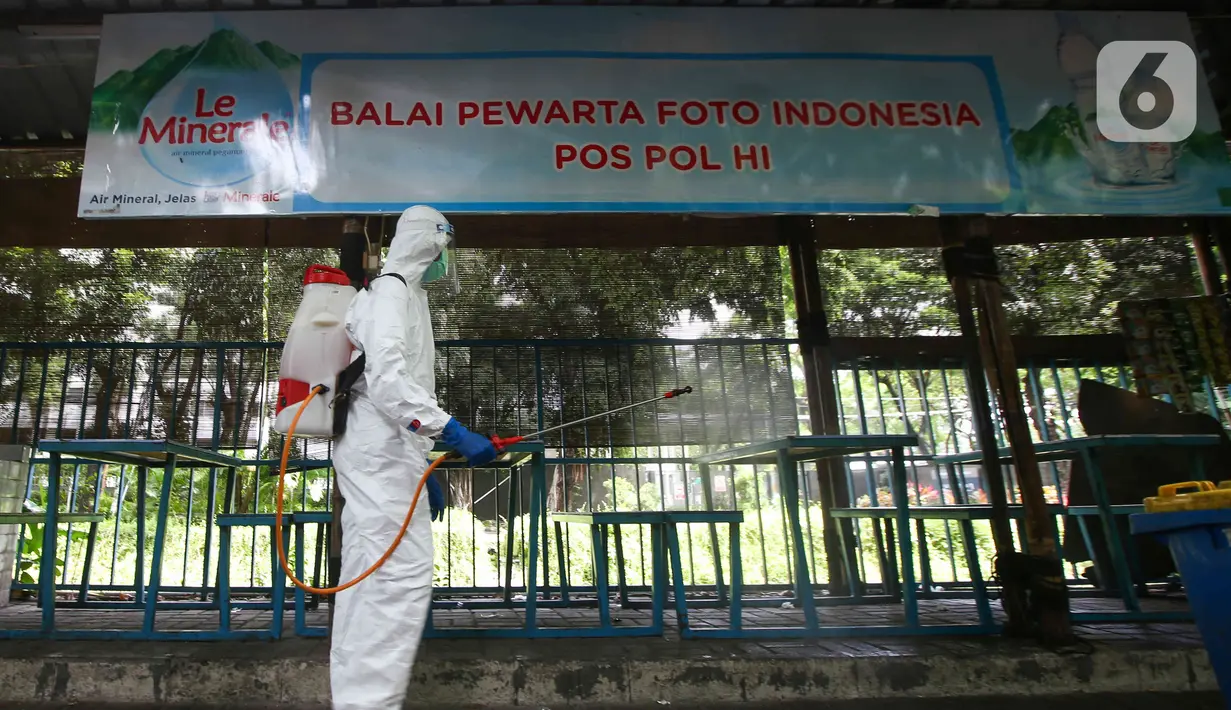 Petugas PMI DKI Jakarta menyempotkan disinfektan di area balai pewarta foto kawasan Bundaran HI, Senin (7/2/2022). Penyemprotan disinfektan untuk sterilisasi di beberapa titik guna mencegah penyebaran COVID-19 varian omicron yang saat ini sedang mengalami peningkatan (Liputan6.com/Herman Zakharia)
