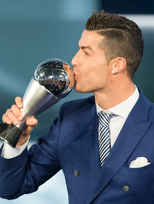 Cristiano Ronaldo mencium trofi penghargaan Pemain Terbaik Dunia FIFA 2016 pada acara Best FIFA Football Awards di Zurich, Senin (9/1). Gelar ini melengkapi kesuksesan Ronaldo yang memperoleh Ballon d'Or 2016. (Ennio Leanza/Keystone via AP)