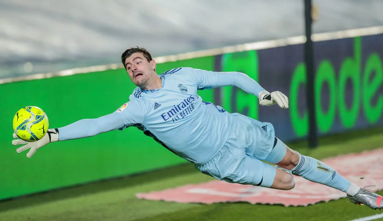 Kiper Real Madrid, Thibaut Courtois, menghalau bola yang mengarah ke gawangnya saat melawan Athletic Bilbao pada laga Liga Spanyol di Stadion Alfredo Di Stefano, Rabu (16/12/2020). Real Madrid menang dengan skor 3-1. (AP/Bernat Armangue)