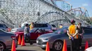 Orang-orang duduk di dalam mobil mereka di area observasi untuk memeriksa kemungkinan efek samping setelah mendapatkan suntikan vaksin di pusat vaksinasi Covid 19 skala besar yang didirikan di Six Flags Magic Mountain di Valencia, California, Selasa (2/2/2021). (VALERIE MACON/AFP)