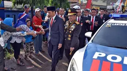 Presiden Joko Widodo menyalami warga saat berjalan menuju lokasi upacara HUT ke-72 TNI di Pelabuhan Indah Kiat, Banten (5/10). Karena kendaraan terjebak macet, Presiden Jokowi memilih berjalan kaki menuju lokasi upacara. (Liputan6.com/Pool/Agus Suparto)