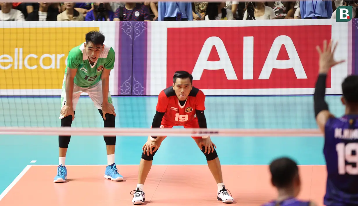 Dua pemain tim voli putra Indonesia, Fahreza Rakha (depan) dan Rivan Nurmulki bersiap menerima serve yang dilepaskan pemain Kamboja pada laga ketiga Grup A SEA Games 2023 di Olympic Complex Indoor Main Hall, Phnom Penh, Kamboja, Sabtu (6/5/2023). Tim bola voli Putra Indonesia menang 3-0 (25-18, 25-21, 25-16) dan memastikan lolos ke semifinal sebagai juara Grup A. (Bola.com/Abdul Aziz)