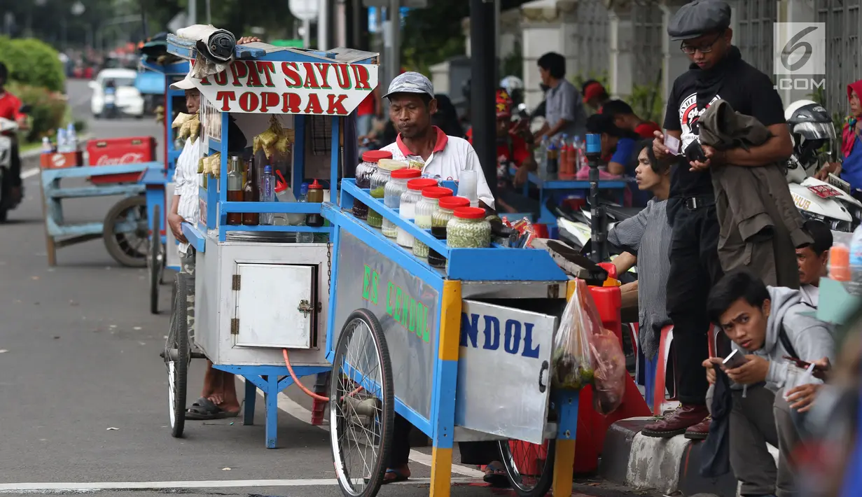 Pedagang kaki lima menjajakan makanan dan minuman di sisi jalan sekitar kawasan Patung Kuda Jakarta, Rabu (5/1/2019). Mereka mencoba peruntungan saat para buruh melakukan aksi perayaan Hari Buruh International atau May Day. (Liputan6.com/Helmi Fithriansyah)