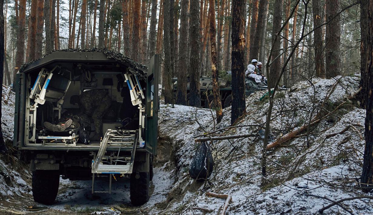 Petugas medis militer memberikan pertolongan pertama kepada seorang tentara yang terluka dalam pertempuran dekat Kremenna di wilayah Luhansk, Ukraina, 16 Januari 2023. Hingga saat ini pejabat Ukraina menolak untuk mengonfirmasi jumlah korban dalam perangnya dengan Rusia, setelah ketua Komisi Uni Eropa pada akhir November 2022 lalu memperkirakan bahwa "lebih dari 20.000 warga sipil dan 100.000 tentara Ukraina telah tewas di Ukraina hingga saat ini." (AP Photo/LIBKOS)