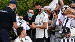 Bukan hanya swafoto, Cristiano Ronaldo pun menyempatkan menandatangani baju bola bernomor punggung 7 milik salah satu penggemar. (Foto: AFP/Miguel Medina)