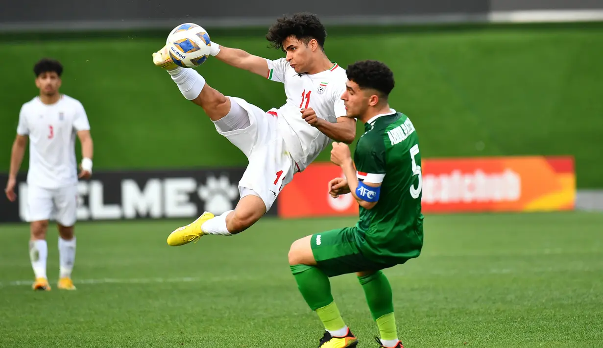 Pemain Iran U-20, Amirreza Eslamtalab melepaskan tendangan di depan pemain Irak U-20, Abdulrazzak Qasim Subaihawi pada laga perempatfinal Piala Asia U-20 2023 di JAR Stadium, Tashkent, Uzbekistan, Sabtu (11/3/2023). (AFC/Adam Aidil)