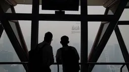 Wisatawan melihat pemandangan kota yang diselimuti kabut asap pekat dari Kuala Lumpur Tower, Kuala Lumpur, Malaysia, Jumat (13/9/2019). Pemerintah Malaysia berencana membuat hujan buatan untuk mengurangi kabut asap. (AP Photo/Vincent Thian)