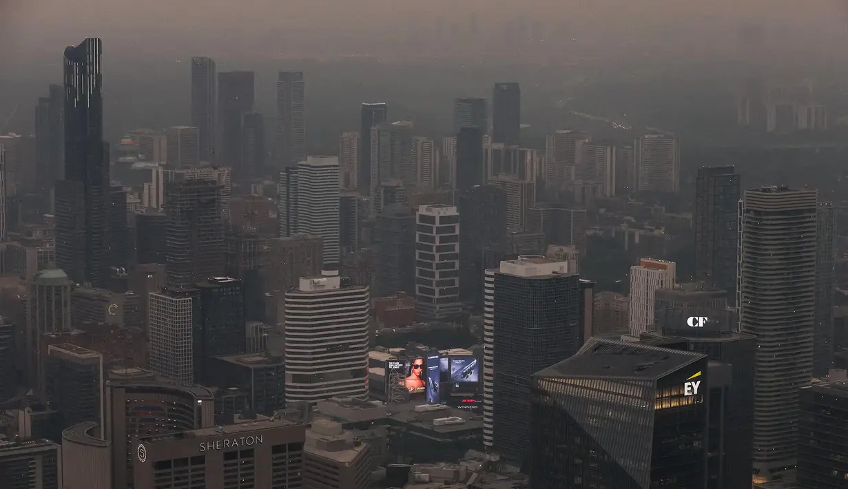 Pemandangan gedung-gedung pusat kota terlihat dari Menara CN saat asap akibat kebakaran hutan di Ontario Utara menyelimuti Toronto dan menyebabkan kualitas udara memburuk, di Toronto, Ontario, Kanada, Kamis, 15 Juli 2026. (AFP/ Cole Burston)