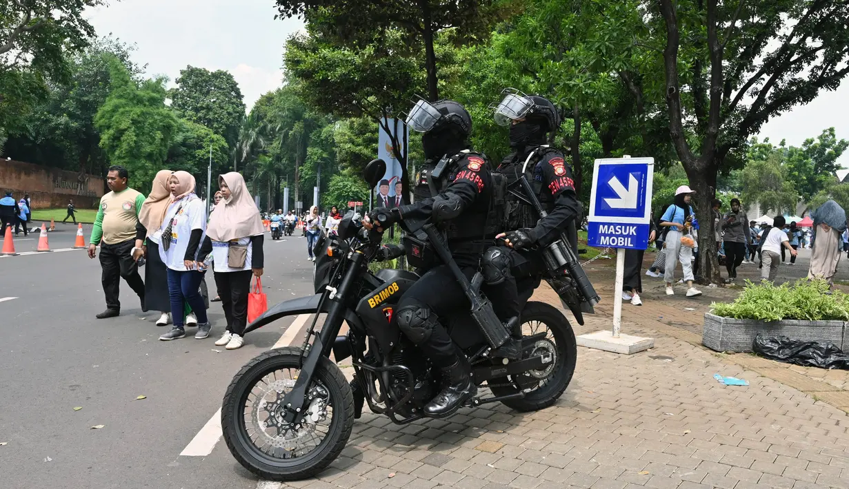 Personel polisi Korps Brigade Mobil berpatroli dengan sepeda motor pada hari terakhir kampanye di Jakarta pada tanggal 10 Februari 2014. (ADEK BERRY/AFP)
