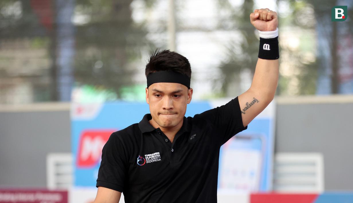 <p>Ekspresi artis yang sekaligus atlet MMA, Randy Pangalila, saat meraih poin atas lawannya, Rezky Aditya, dalam pertandingan tenis tunggal putra Turnamen Olahraga Selebriti Indonesia yang berlangsung di Gelanggang Olahraga UNJ, Rawamangun, Jakarta Timur, Sabtu (29/7/2023). Pertandingan kali ini berhasil dimenangkan oleh Rezky Aditya dengan dua set langsung (1-6 - 1-6). (Bola.com/Abdul Aziz)</p>