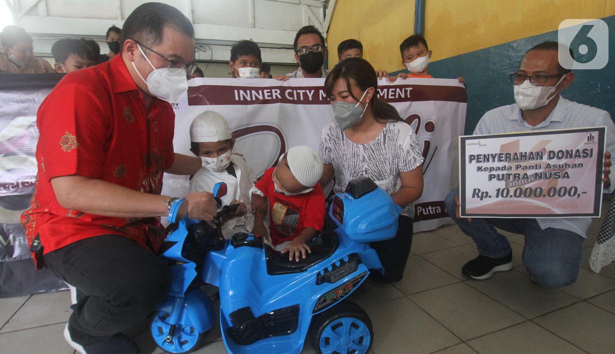 Ketua PPRS Apartemen Sudirman Park Rusli Usman (kiri) dan Ketua Panitia HUT ke-16 ICM Anggie Febrianti secara simbolis memberikan mainan kepada anak-anak panti asuhan di Yayasan Putra Nusa Jakarta, Jakarta (2/03/2022). (Liputan6.com/HO/ICM)