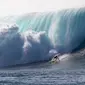 Peselancar Kohl Christensen menjelajah ombak besar di Pantai Utara O’ahu, Hawaii, Senin (26/11). (Brian Bielmann / AFP)