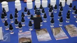 Sejumlah botol serta bahan baku pembuatan cairan rokok elektrik berbahan ganja ditampilkan di Mapolres Jakarta Selatan, Selasa (21/3). Petugas berhasil mengamankan tersangka AA beserta barang bukti. (Liputan6.com/Immanuel Antonius)