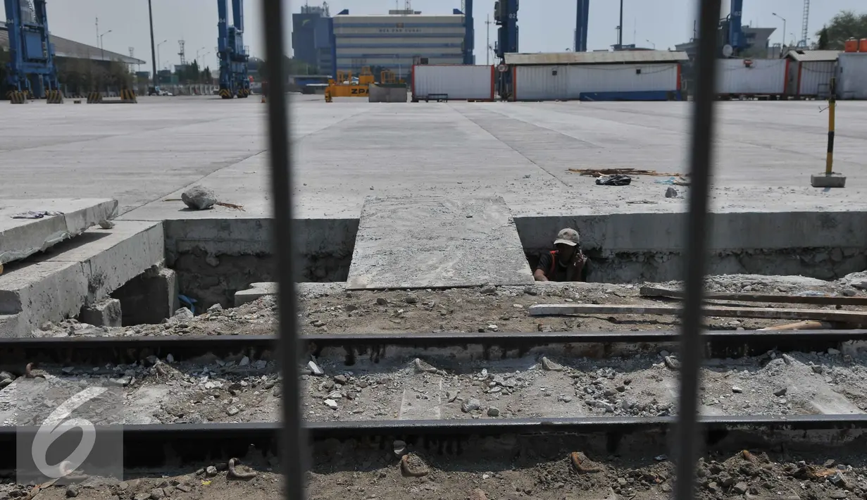 Pekerja membongkar rel kereta utama pelabuhan yang tertutup beton di Pelabuhan Tanjung Priok, Jakarta, Jumat (11/9/2015). Penutupan jalur kereta membuat tidak efisiensi waktu bongkar pasang serta menambah kemacetan. (Liputan6.com/Gempur M Surya)