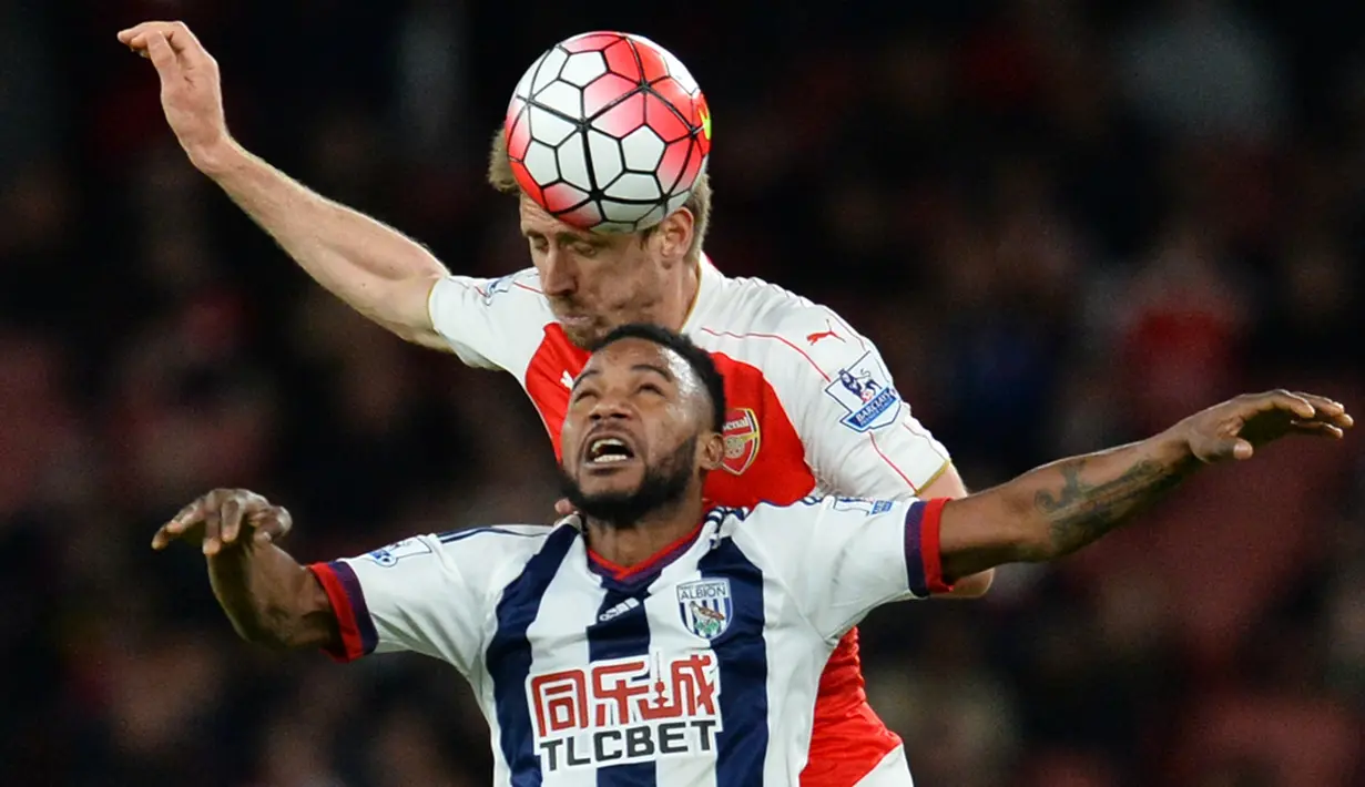 Duel antara pemain Arsenal, Nacho Monreal (atas), dengan pemain West Bromwich Albion, Stephane Sessegnon, pada lanjutan Liga Inggris di Stadion Emirates, London, Jumat (22/4/2016) dini hari WIB. (AFP/Glyn Kirk)