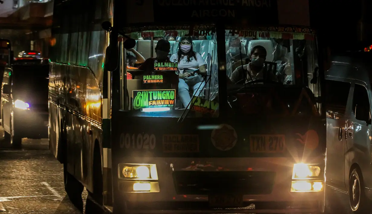 Penumpang mengenakan masker di dalam sebuah bus yang terjebak macet di Manila (3/8/2020). Kemacetan terjadi ketika orang-orang bergegas keluar dari Metro Manila beberapa jam sebelum pemerintah memberlakukan lockdown di kawasan itu akibat lonjakan kasus penyakit Covid-19. (Xinhua/Rouelle Umali)