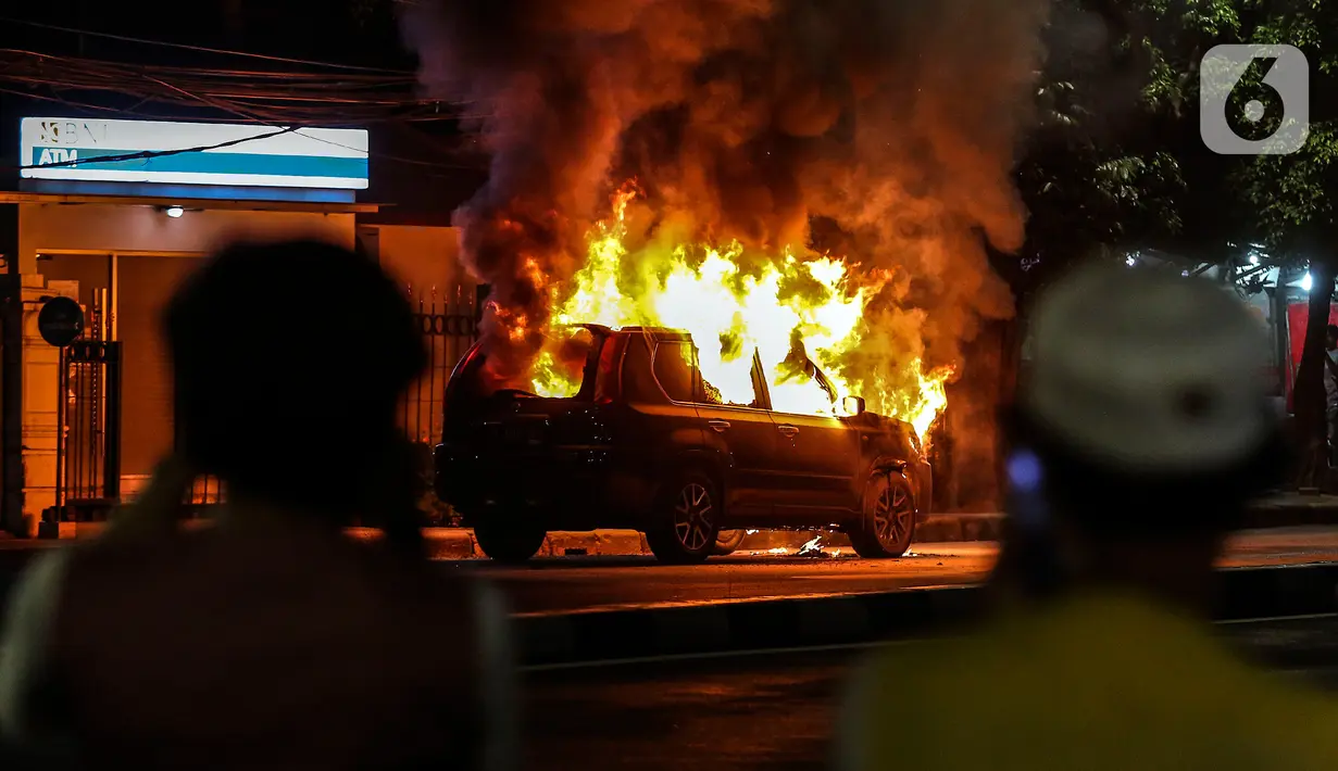 Sebuah mobil terbakar di Jalan Asia Afrika, Jakarta, Kamis (18/3/2021) dinihari. Kobaran api yang melahap mbil jenis minibus bernomor polisi B 1608 SGZ itu menjadi tontonan warga. (Liputan6.com/Johan Tallo)