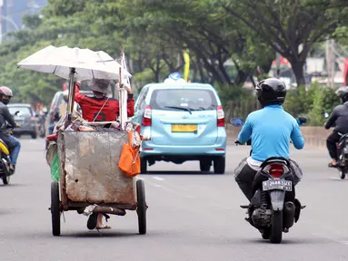 Tuna wisma menarik gerobaknya saat melintas di Jalan Margonda Raya, Depok, Kamis (16/4/2020). Pandemi COVID-19 memberikan dampak yang sangat besar bagi sosial dan ekonomi Indonesia. Bahkan yang paling dikhawatirkan bertambahnya angka kemiskinan dan pengangguran. (Liputan6.com/Helmi Fithriansyah)