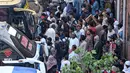 Orang-orang berkumpul di terminal bus saat mereka pulang menjelang hari raya Idul Adha, di sebuah terminal bus di Lahore, Pakistan pada 27 Juni 2023. (Photo by Arif ALI / AFP)