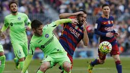 Gelandang Barcelona, Arda Turan, berebut  bola dengan gelandang Getafe, Alvaro Medran. Sementara bagi Getafe kekalahan ini membuat mereka terpuruk ke posisi 17, setinggat di atas zona degragasi. (Reuters/Albert Gea)