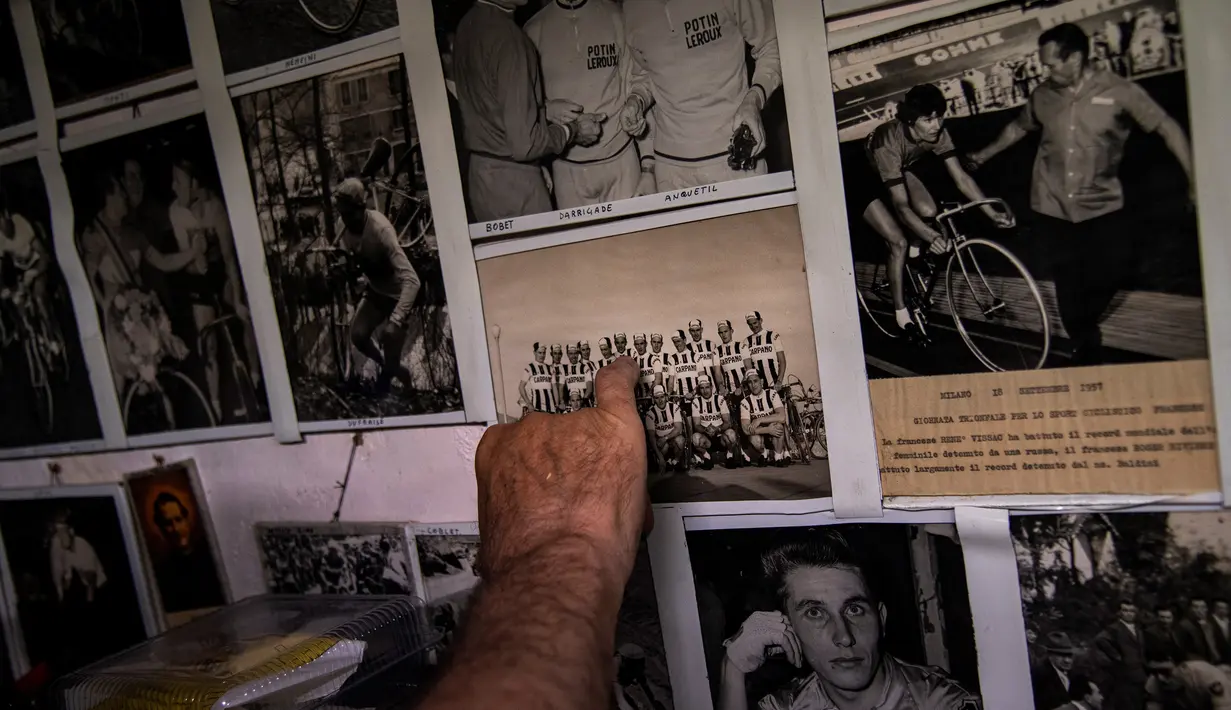 Raffaello Bianco, mekanik dan pecinta sepeda bekerja menunjukkan gambar tim pro tahun 1950-an-60an "Carpano" di bengkel mekaniknya di ruang bawah tanah apartemennya di Turin, Italia, 7 Juli 2020. Bianco mengatakan selalu memiliki gairah yang lebih besar terhadap sepeda. (MARCO BERTORELLO/AFP)