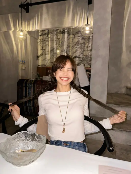 Manisnya penampilan Lisa BLACKPINK dengan rambut panjang yang dibagi dua dan dikepang. Poninya dibelah menjadi poni tirai mempermanis penampilannya secara keseluruhan. [Foto: Instagram/lalalalisa_m]