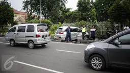 Pengendara lain melitas disamping mobil yang menabrak separator busway matraman arah kampung melayu, Jakarta, Sabtu (25/2). Akibat kecelakaan ini lalu lintas kawasan jalan matraman mengarah kampung melayu tersendat. (Liputan6.com/Faizal Fanani)
