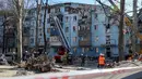 Tim penyelamat Ukraina di eskalator bekerja di bangunan tempat tinggal lima lantai yang hancur setelah serangan rudal di tengah invasi Rusia ke Ukraina di Zaporizhzhia pada 2 Maret 2023. Serangan Rusia di sebuah blok apartemen di kota Zaporizhzhia, Ukraina selatan telah menewaskan sedikitnya tiga orang, kata pihak berwenang setempat pada 2 Maret, saat operasi pencarian sedang berlangsung. (AFP/Katerina Klochko)