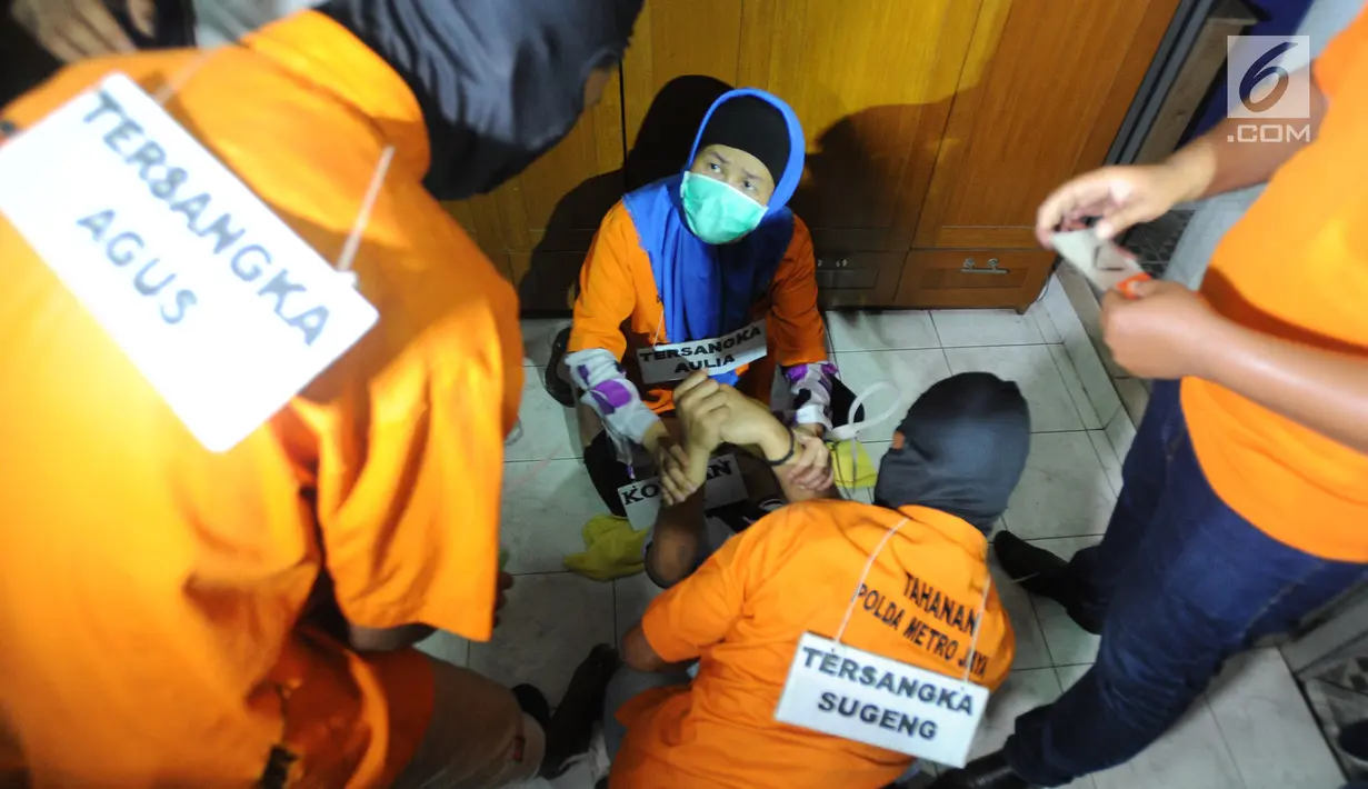 Tersangka Aulia Kesuma (tengah) saat rekonstruksi pembunuhan suami dan anak tirinya di Jalan Lebak Bulus 1, Cilandak, Jakarta Selatan, Kamis (5/9/2019). Saat itu, korban sempat melawan hingga melukai tersangka Aulia Kesuma. (merdeka.com/Arie Basuki)