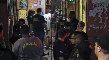 Sejumlah petugas saat mengevakuasi korban penembakan massal di sebuah bar di kota Belm, negara bagian utara Par, Brazil (19/5/2019). Sebanyak 11 orang dilaporkan tewas dalam serangan yang dilakukan 7 pria bersenjata tersebut. (Claudio Pinheiro/Agencia Panamazonica/AFP)