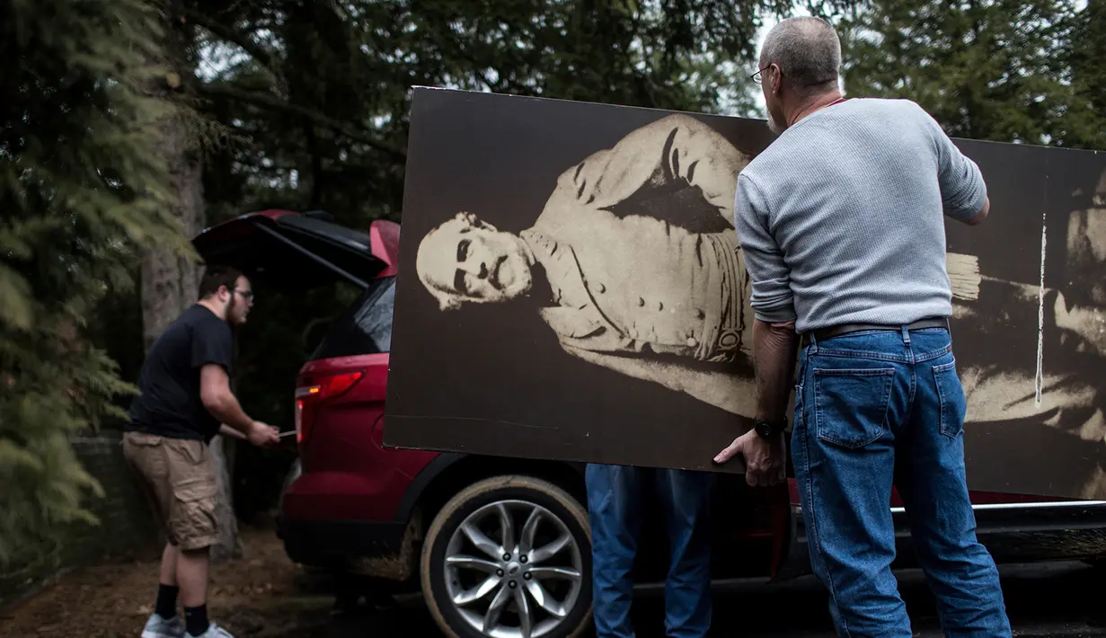 Pengunjung membawa koleksi lukisan yang beli dari Museum Hall of Presidents di Gettysburg, Pennsylvania, Sabtu (14/1). Museum yang tutup pada November lalu tersebut menjual hampir seluruh koleksi mereka. (AP Photo/ SEAN SIMMERS)