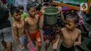 Anak-anak korban banjir bermain di luar Gedung Sekolah SDN 01/02 Kampung Melayu, Jakarta, Selasa (9/2/2021). Gedung sekolah tersebut menjadi salah satu posko pengungsian bagi Sebagian korban banjir di kawasan Kebon Pala. (Liputan6.com/Faizal Fanani)