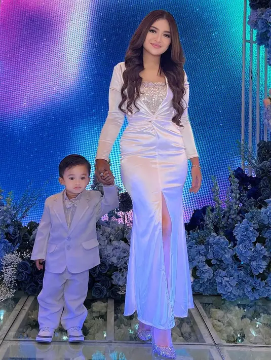 Natalie tampil anggun dibalut slit dress putih lengan panjang. Asam pun tampil mengenakan setelan jas putih lengkap dengan dasi kupu-kupunya.  [@nathalieholscher]