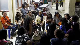 Sejumlah keluarga korban jatuhnya pesawat Hercules C-130 milik TNI AU menunggu di depan RSUP Adam Malik, Medan, Selasa (30/6/2015). Pesawat berpenumpang 122 orang tersebut terjatuh dan menimpah pemukiman warga. (REUTERS/Beawiharta)
