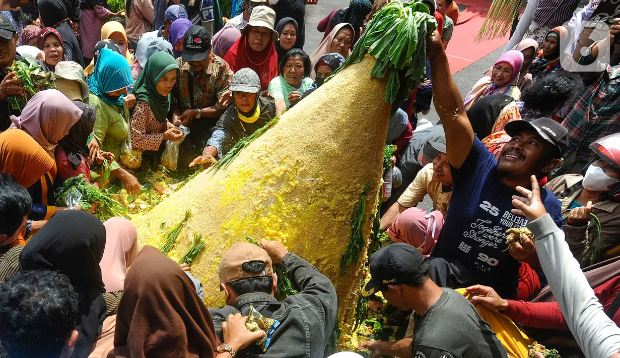 Warga berebut tumpeng hasil pertanian di halaman Pendopo Kabupaten Trenggalek, Jawa Timur, Kamis (31/8/2023). (merdeka.com/arie basuki)
