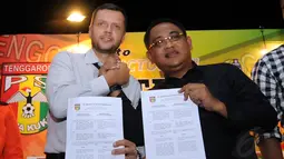 Scott Cooper (kiri) bersama Presiden klub Mitra Kukar, Endri Erawan memperlihatkan kontrak kerja kepada sejumlah wartawan di Jakarta, (11/12/2014). (Liputan6.com/Helmi Fithriansyah)