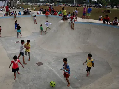 Sejumlah anak bermain di area skate board di Kalijodo, Jakarta, Rabu (4/1). Mengisi hari libur Kalijodo dipenuhi ratusan warga, Anak - anak, orang tua, remaja bermain memeras tenaga untuk memuaskan adrenalin mereka. (Liputan6.com/Johan Tallo)
