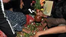 Tak kuat menahan air mata, anak Mpok Nori bersimpuh di makam ibunya (Foto: Muhammad Akrom Sukarya)