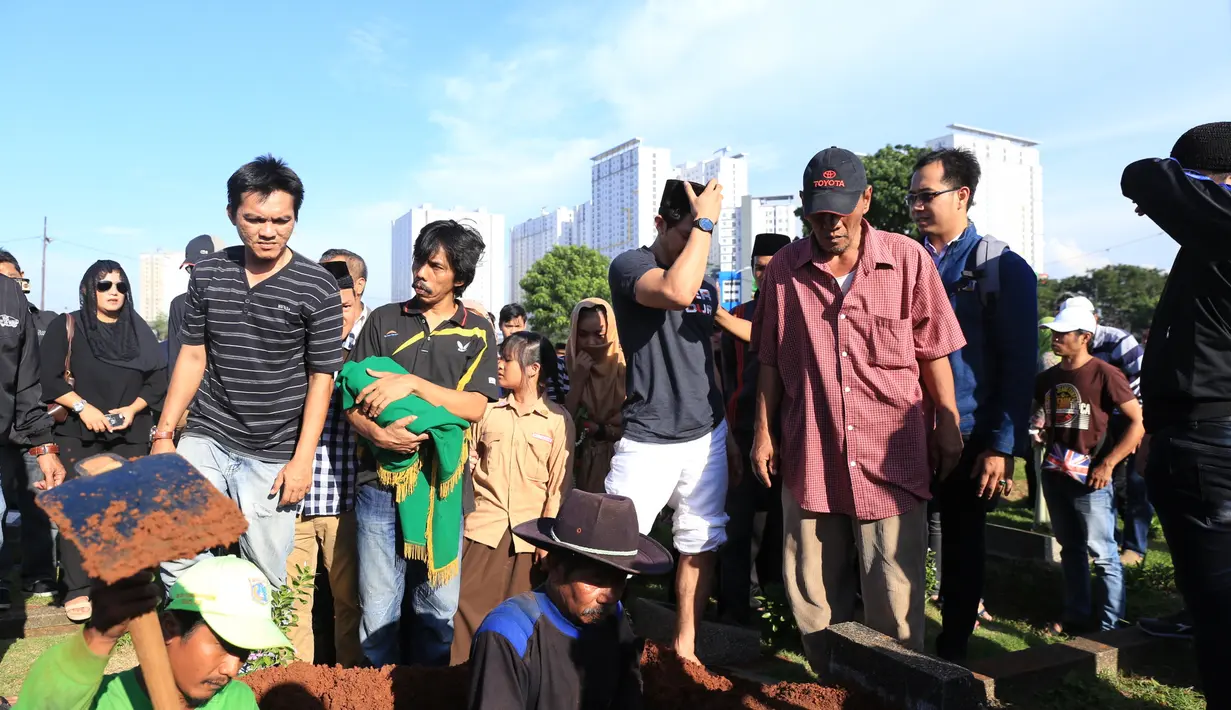 Meski terlihat tegar, Iko yang mengenakan kaos hitam dan celana putih serta kopiah hitam itu juga tak kuasa menahan air matanya ketika pembacaan doa. Sang istri setia mendampinginya. (Adrian Putra/Bintang.com)