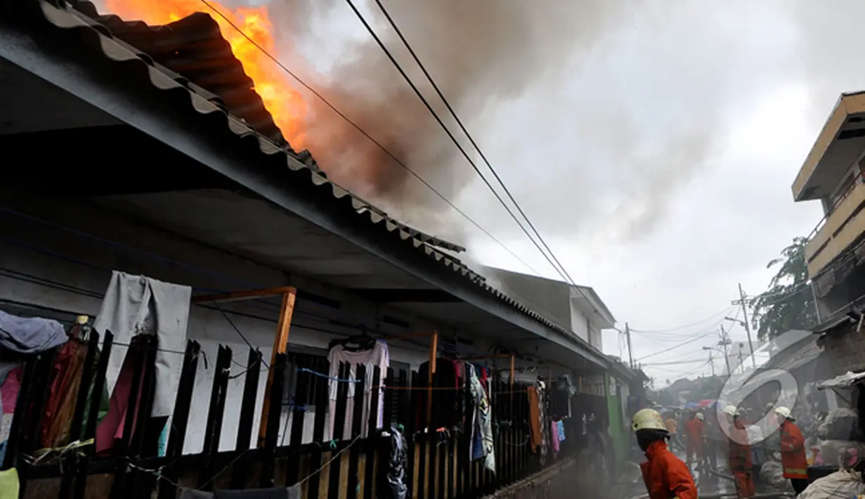 Petugas pemadam kebakaran berusaha memadamkan api yang membakar pemukiman penduduk di kawasan Pasar Kembangan, Senen, Jakarta, Senin(19/1/2015).  (Liputan6.com/Miftahul Hayat)