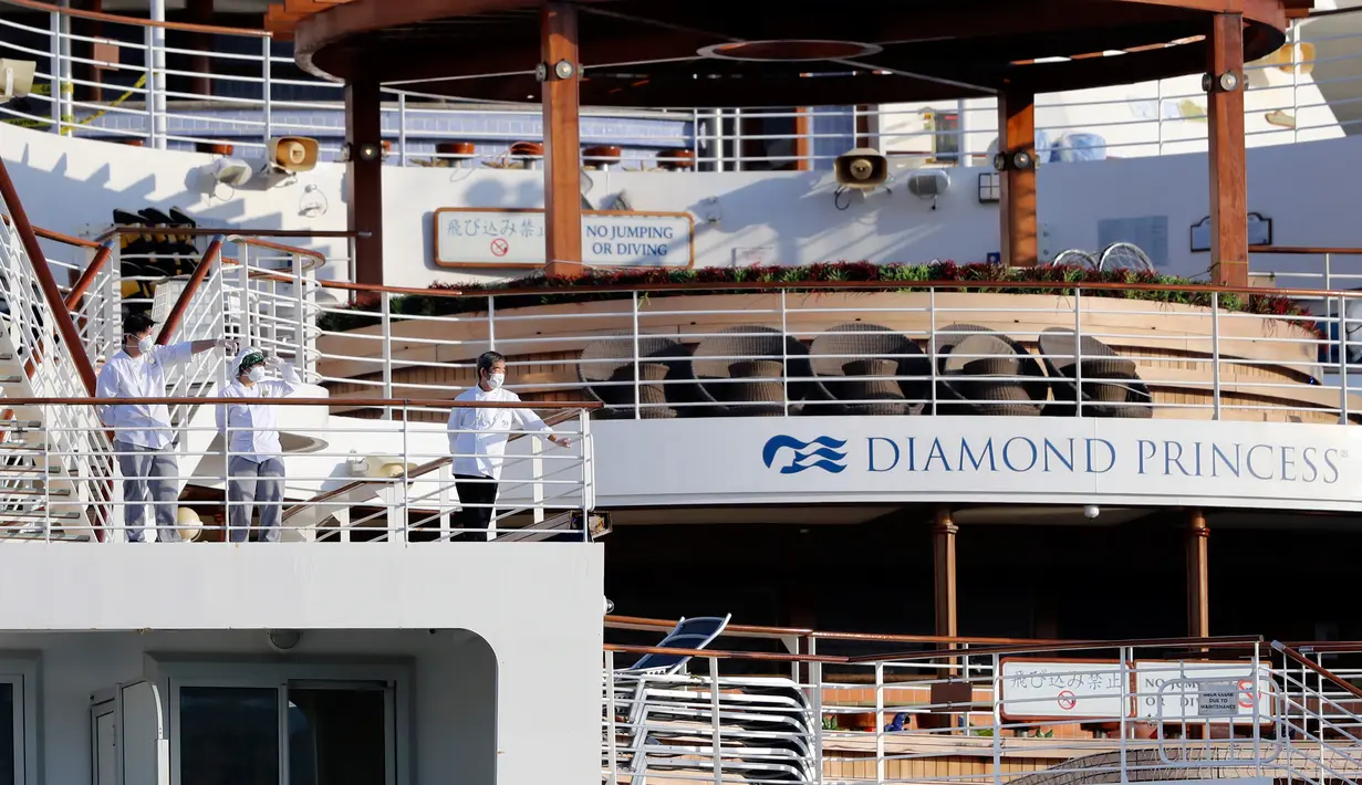 Kru berdiri di geladak kapal pesiar Diamond Princess yang dikarantina di Yokohama, Jepang, Jumat (21/2/2020). Sebanyak 634 dari 3.711 orang kapal pesiar Diamond Princess kini terjangkit virus corona (COVID-19). (AP Photo/Eugene Hoshiko)