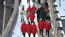 Wisatawan berjalan  menikmati suasana salju di lingkungan Tembok Besar China di utara Beijing (6/1/2020). Salju yang turun tidak menyurutkan para wisatawan baik lokal maupun dari mancanegara untuk berkunjung ke Tembok Besar China. (AFP/Greg Baker)
