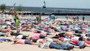 Ribuan orang terbaring diatas pasir untuk memecahkan Guinness World Record dalam membuat "Sand Angels" di Pantai Stearns Park, Ludington (10/6). Dalam acara ini, 27 orang didiskualifikasi karena berbagai alasan. (Jeff Kiessel/Ludington Daily News via AP)