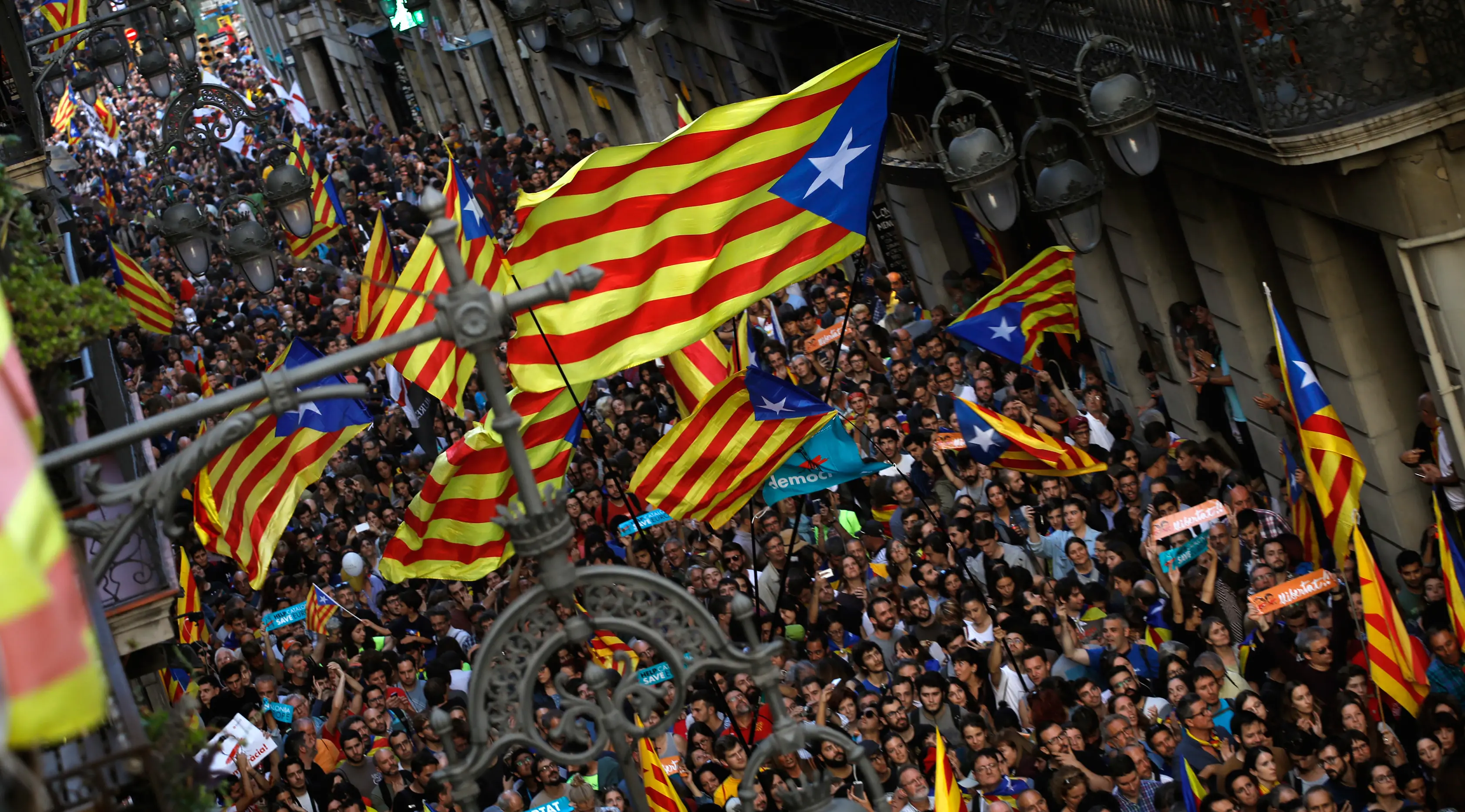 Para pendukung pro-kemerdekaan berkumpul di luar Gedung Palau Generalitat, Barcelona, Jumat (27/10). Parlemen regional Catalonia mendeklarasikan kemerdekaan dari Spanyol melalui pemungutan suara. (AP/Emilio Morenatti)